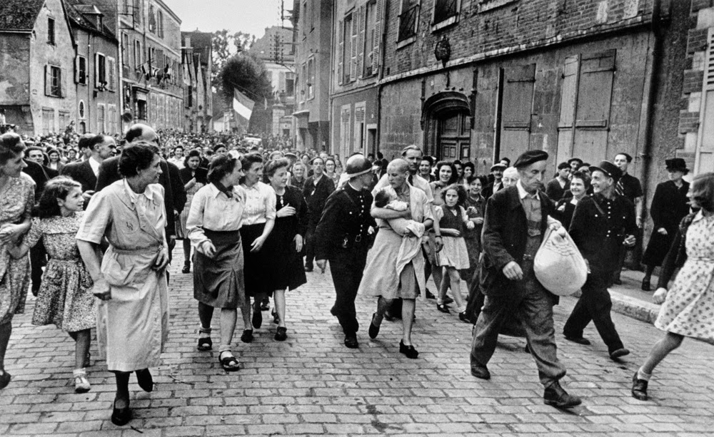 Simone Touseau, a French collaborator, being marched through the streets of Chartres prior to the liberation of France by the Allies.